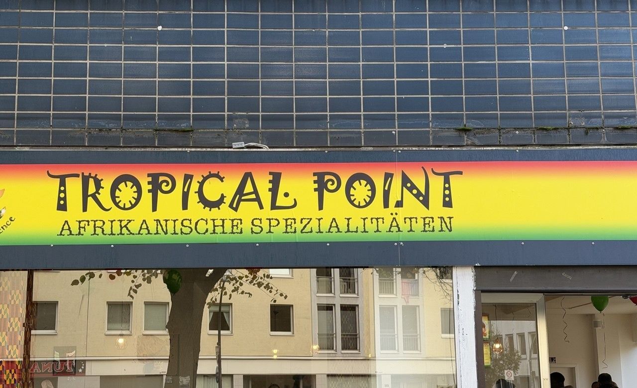 Schild über dem Eingang: Tropical Point, Afrikanische Spezialitäten